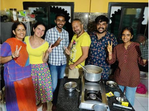 a group of people standing in a kitchen at Black Pepper Home Stay in Udaipur