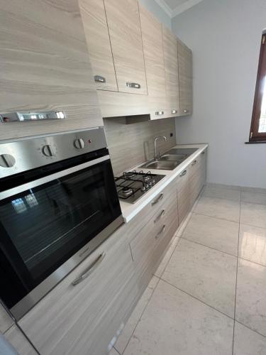 a kitchen with wooden cabinets and a stove top oven at Patricia’s House in Striano