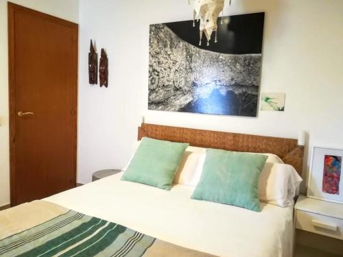 una camera da letto con un letto e un dipinto sul muro di Ca n'Antonia Formentera a Sant Francesc Xavier