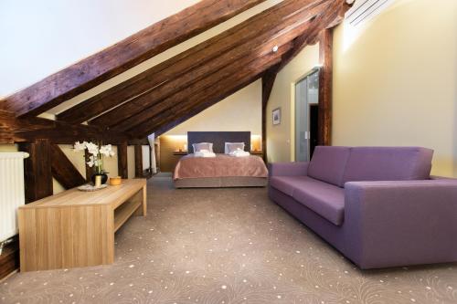 a bedroom with a purple couch and a bed at Bern Boutique Hotel in Tallinn