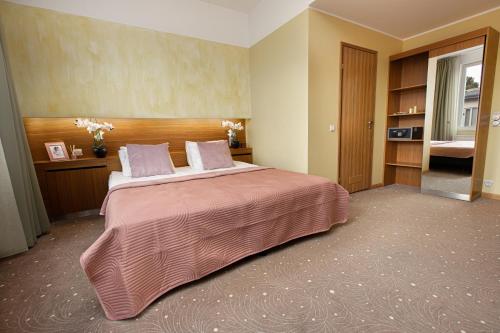 a bedroom with a large bed with a pink blanket at Bern Boutique Hotel in Tallinn