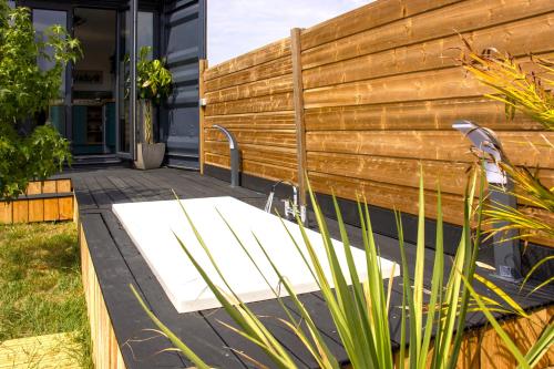 a bench on a patio next to a wooden fence at Le Cabin Charbonnaud in Laprade