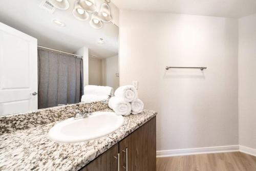a bathroom with a sink and a mirror at Chic Downtown Waco Apartment in Waco