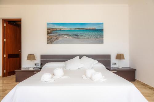 1 dormitorio con cama blanca y almohadas blancas en Villa Puigverd, en Felanitx