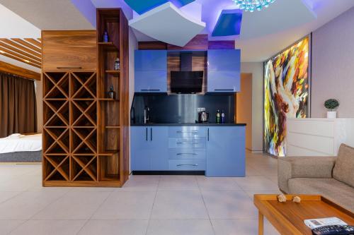 a living room with a kitchen with blue cabinets at The SPOT apartments - Orbi Beach Tower in Batumi