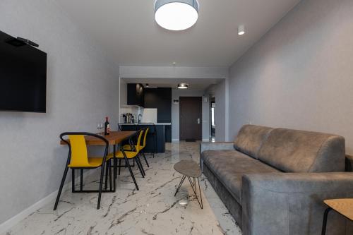 a living room with a couch and a table and chairs at The SPOT apartments - Orbi Beach Tower in Batumi
