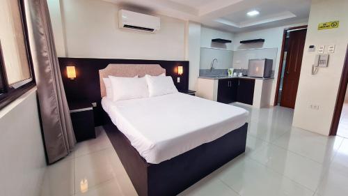 a bedroom with a large bed in a room at Staycation Hotel in San Jose