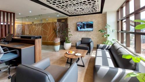 ein Büro mit einem Sofa, einem Schreibtisch und einem Tisch in der Unterkunft Hotel Mokka City in Nairobi