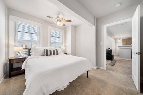 a white bedroom with a bed and a ceiling fan at Trendy Downtown Waco Apartment With Great View in Waco
