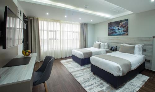a hotel room with two beds and a television at Hotel Mokka City in Nairobi