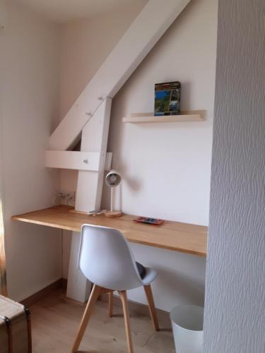 een bureau en een stoel in een kamer met een trap bij Kerlann Bruz in Bruz