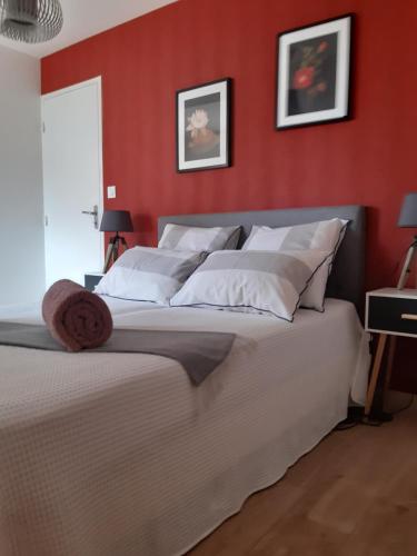 1 dormitorio con paredes rojas y 1 cama con almohadas blancas en Kerlann Bruz, en Bruz