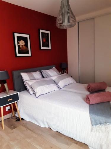 1 dormitorio con cama blanca y pared roja en Kerlann Bruz, en Bruz