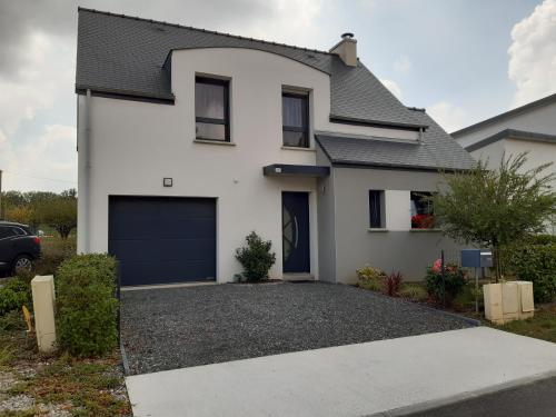 a white house with a garage at Kerlann Bruz in Bruz