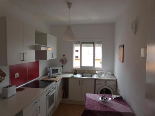 a kitchen with white cabinets and a sink and a window at Pepe y Nina in Las Lagunas