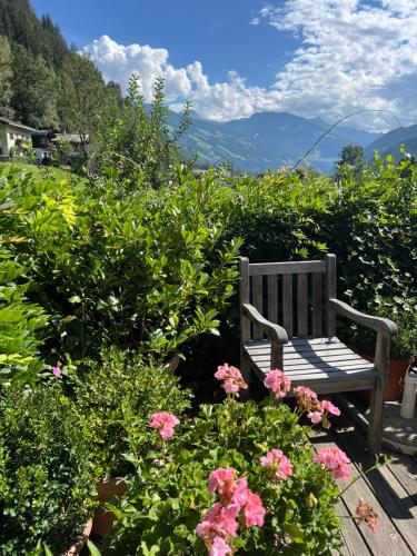 a wooden bench sitting in a garden with flowers at Landgasthof Hotel Linde in Stumm