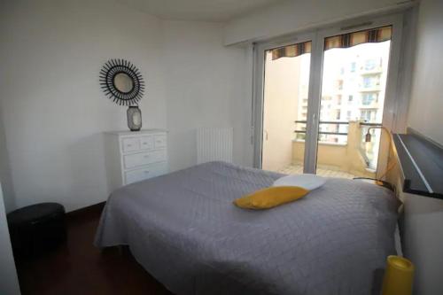een slaapkamer met een bed met een geel kussen erop bij Midoon guest - The Balcony - Grand appartement Créteil proche Paris in Créteil