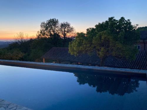 a swimming pool with a sunset in the background at Casa Dormiveglia in Montaldo Bormida