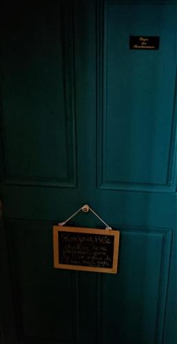 a blue wall with a sign hanging on it at À l'étape des randonneurs in Saignon