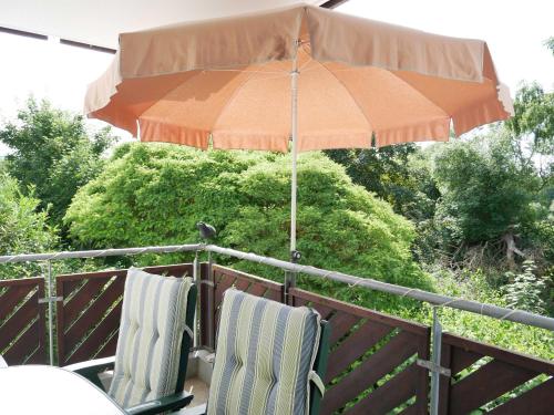 zwei Stühle unter einem Schirm auf einem Deck in der Unterkunft Seepark Bansin,  App. 107 Haus 1, Benzmann in Bansin