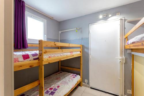 zwei Etagenbetten in einem Zimmer mit Fenster in der Unterkunft Beau studio avec grande terrasse in La Grande-Motte