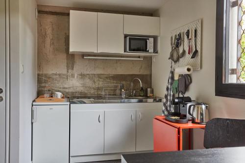 a kitchen with white cabinets and a sink at LA PORTE ROUGE RBX in Roubaix