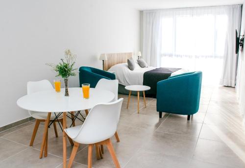 uma sala de estar com uma mesa branca e cadeiras em CQ MITRE em Puerto Madryn