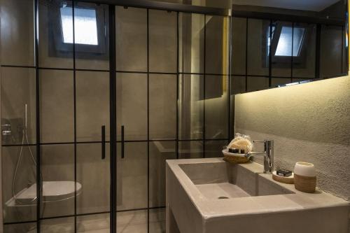 a bathroom with a sink and a toilet and a mirror at Soas Suites in Alaçatı