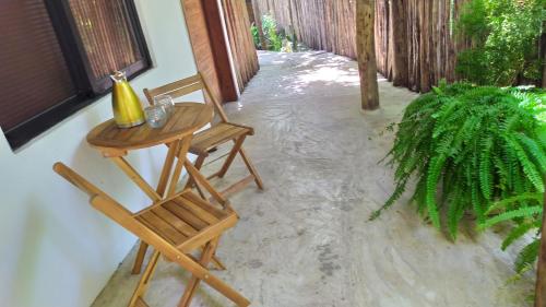 a table and two chairs sitting on a patio with water at Estancia Lapislázuli in Bacalar