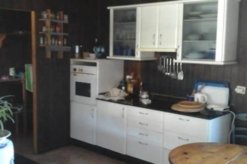 eine Küche mit weißen Schränken und einem weißen Kühlschrank in der Unterkunft Chalet Rural Marian in Santa Maria de Guia de Gran Canaria