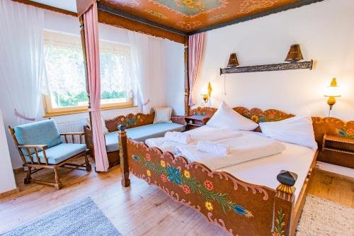 een slaapkamer met een groot bed en een stoel bij Bergidyll 9 by Alpenidyll Apartments in Ramsau am Dachstein