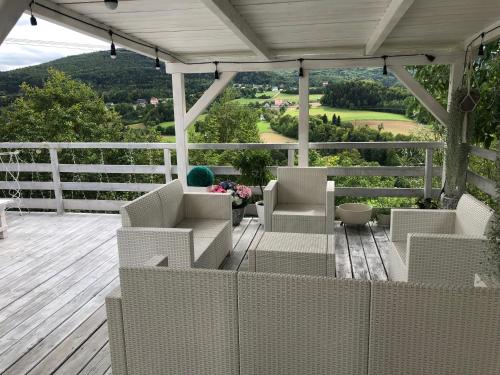 a porch with white chairs and a view of a valley at Koperkowy Raj Beskid Wyspowy Domek Małopolska Jacuzzi Playroom in Laskowa