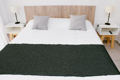 a bedroom with a large bed with white sheets and pillows at CQ MITRE in Puerto Madryn