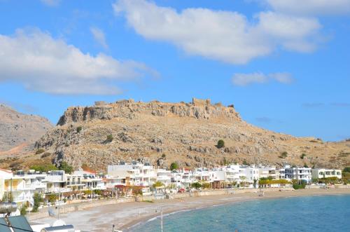 a view of a beach with a mountain in the background at Georgias Apartments in Haraki