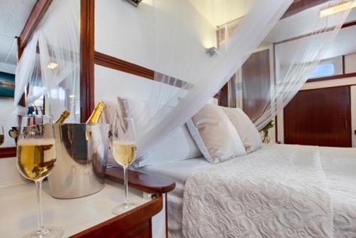 um quarto com uma cama e dois copos de vinho em Charming Boat in Barcelona - Perfect getaway em Barcelona