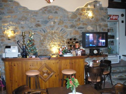 a bar with a tv on a stone wall at Seirios in Vizitsa