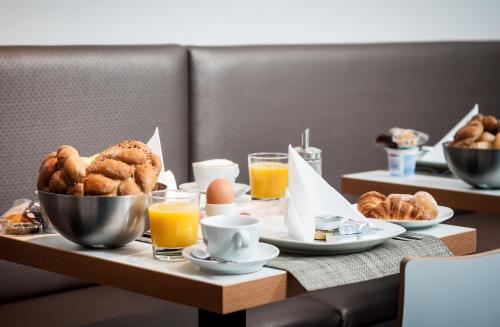 a breakfast table with eggs and pastries and orange juice at VV hotel & apartments in Brno