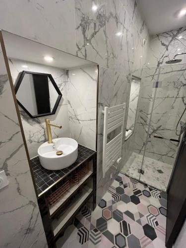 a white bathroom with a sink and a mirror at Superbe appartement - Cholet Centre in Cholet