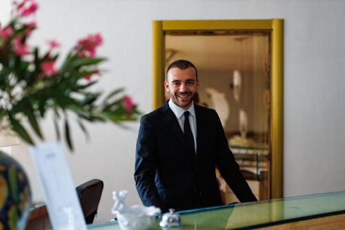 a man in a suit and tie sitting at a table at Alberi del Paradiso in Cefalù
