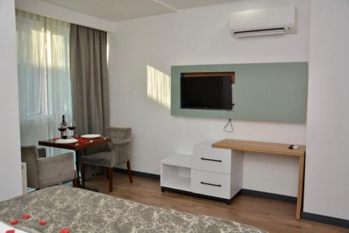 Habitación de hotel con cama, escritorio y TV. en My Sun Hotel, en Izmir