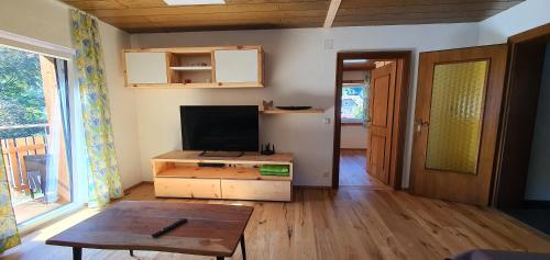 a living room with a flat screen tv and a table at Ferienwohnung Brader in Hallstatt