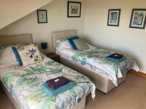 a bedroom with two beds with towels on them at Midkinleith Farm Holiday Cottage in Edinburgh