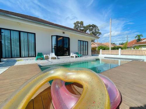 a swimming pool with a slide in front of a house at One season poolvilla in Bang Sare