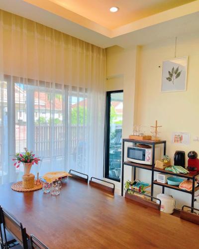 a living room with a table and a microwave at One season poolvilla in Bang Sare