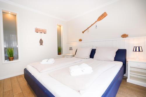 een slaapkamer met een groot wit bed en 2 handdoeken bij Ferienwohnung Daldrup 2 in Grömitz