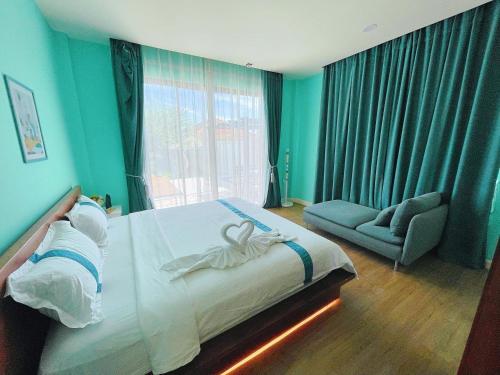 a bedroom with a bed and a chair and a window at One season poolvilla in Bang Sare