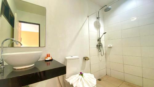 ein Bad mit einem Waschbecken, einem WC und einer Dusche in der Unterkunft Kuapa Resort in Takua Pa