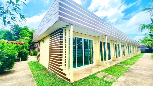 a small yellow building with a gambrel roof at Kuapa Resort in Takua Pa
