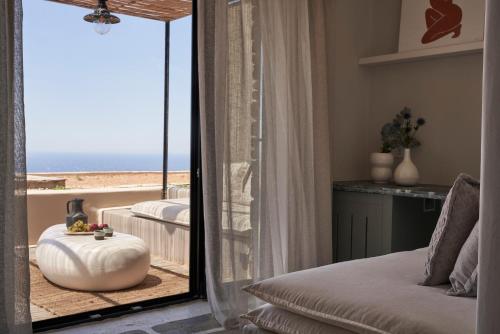 a bedroom with a view of the beach from a mirror at Under the Sun Cycladic Village in Tinos