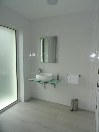 a white bathroom with a sink and a mirror at Kathleen's Carrowkeel Cottage in Sligo